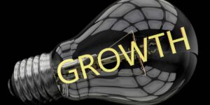 Lampadina contenente la scritta "growth" su uno sfondo completamente nero